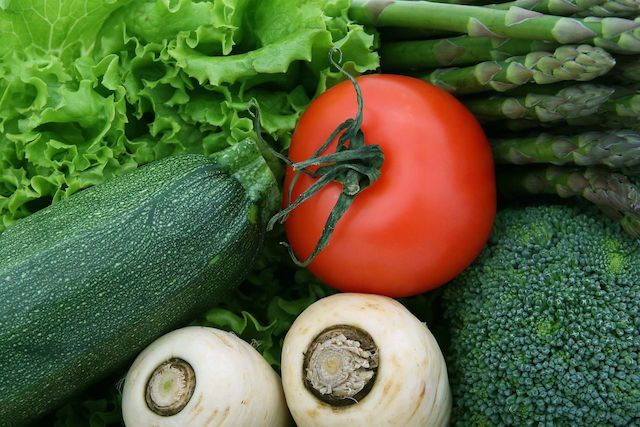 Imagem contendo composição de legumes e verduras. Alface, aspargos, tomate, pepino, nabo e brócolis estão nesta composição.